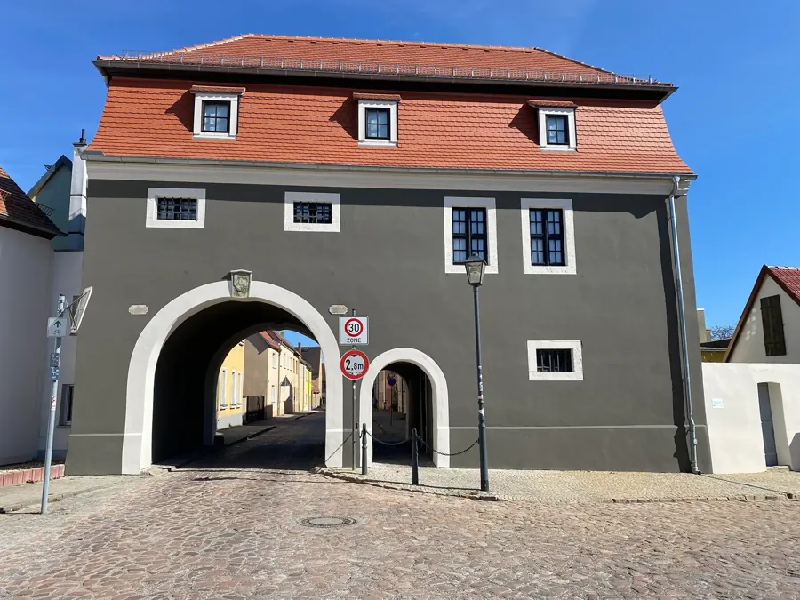 Sanierte dunkle Fassade eines historischen Torhauses